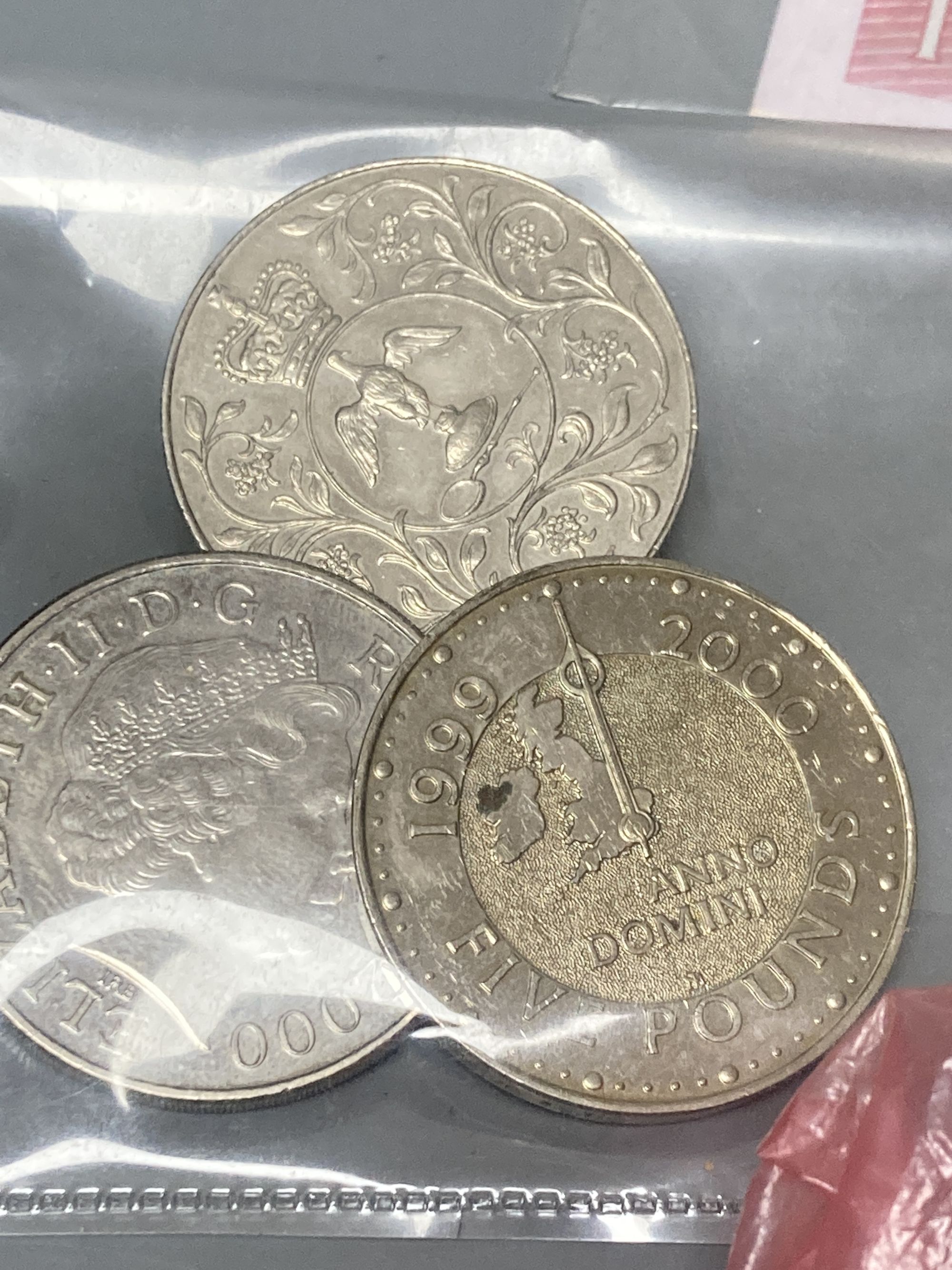 Various coins including Five Pounds coins and mixed world banknotes